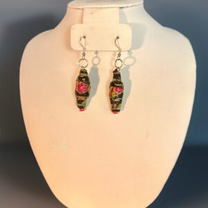 Dangle earrings of paper-based beads that are black with a Venetian glass look design of red roses and green on a white background with silver fixings