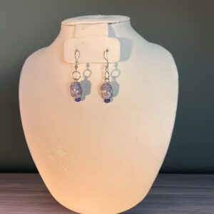 Purple garden paper-based beads in a barrel shaped earring with silver fixings on a neutral background
