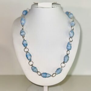 Necklace made of blue beads the light color of acid washed jeans and silver fixings.