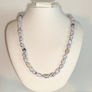Necklace of mini white paper beads with black speckles on a white form with a neutral background