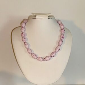 Short necklace of delicate pink beads on a white form with a neutral background