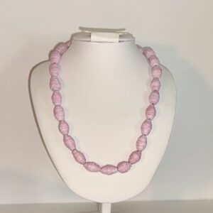 Pink bead necklace on a white form with a neutral background