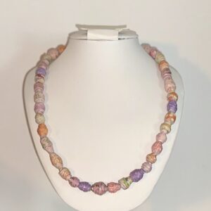 Necklace of Bollywood colors paper beads necklace on white necklace form with a neutral backdrop