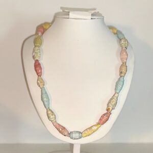 Pastel paper beads in rainbow colors as a necklace on a white form with a neutral background