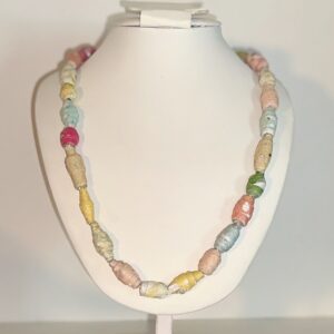 Necklace on white body form with neutral background. Necklace is of paper beads - each in a different color.