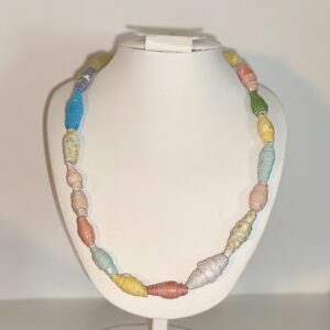 Necklace of rainbow colors with a focus bead of large white glitter paper on a white necklace form with a neutral background