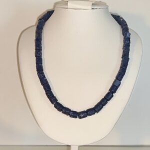Dark navy blue necklace with small paper beads on a white form with a neutral background