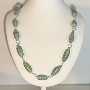Necklace of green striped paper beads with gold fixings on a white form with a neutral background