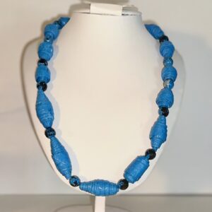 Necklace of bold blue paper beads that look like stones with quartz beads as spacers on a white form with a neutral background