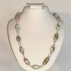Necklace with paper beads showing the pink and green graphic design and the green and blue graphic design with silver fixings on a white necklace form against a neutral background