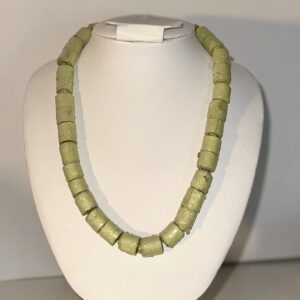 Sage Green Cylinder necklace on a white necklace form with a neutral background