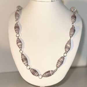 paper bead necklace of dark gray and white that looks like shells with silver fixings on a white form with a neutral background