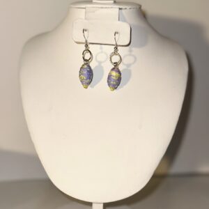 Purple garden paper-based beads in a teardrop shaped earring with silver fixings on a neutral background