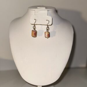 Hippie style paper-based bead earrings in a short cylinder style with gold fixings on a neutral background