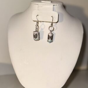 Earrings of silver fixings on white cylinder beads with blue butterflies