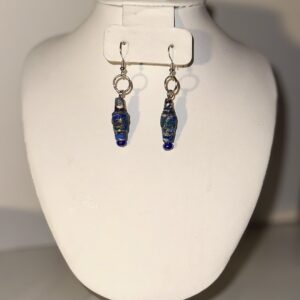 Blue venetian-glass look dangle earrings with silver fixings and paper-based beads with a white base covered with blues in splatter style design.
