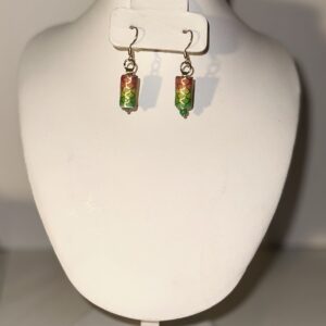 Earrings of gold fixings and mermaid beads of gold, orange, yellow and green, on a neutral surface