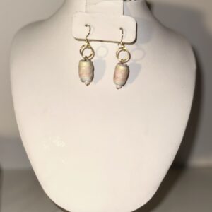 Pink cylinder beads with silver fixings on a neutral background