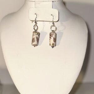 Tan with brown leaf design cylinder earrings with silver fixings on a neutral background