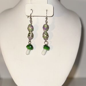 Long dangle earrings with silver fixings made of two paper-based beads made of silver, green, pink and purple paper and Green dappled glass mushroom beads.