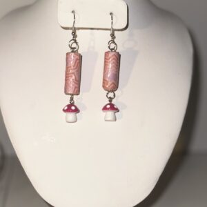 Earrings with silver fixings and long cylinders with pink and red swirls atop a second tier of red capped white mushrooms