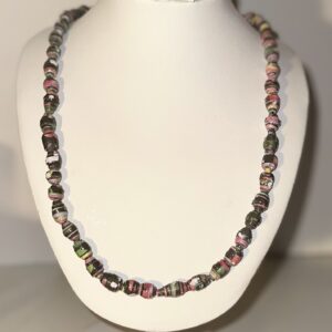Small black beads with pinks on a white form with a beach background