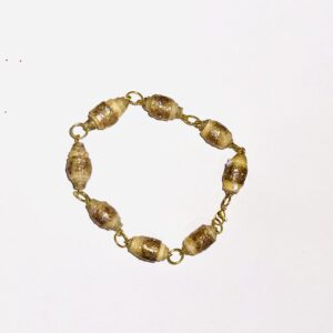 Tan paper-based beads coated with gold glitter, with gold fixings that connect it into a bracelet, on a neutral background