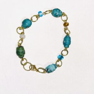 Chain bracelet of bright bold blue paper beads alternating with glass seed beads in white, brown and blue with silver fixings.