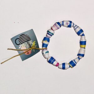 Blue and White striped bead bracelet on a tan colored neutral background