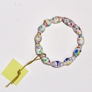 Geometric Rainbow Bracelet with stripes, polka dots, and bold geometric shapes on white base paper on a reddish brown neutral background