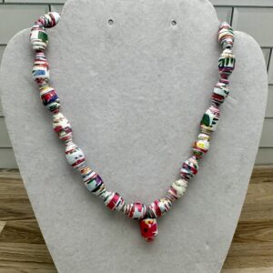 Paper bead necklace of blue based beads with pink and purple floral colors and a blue charm with a red flower